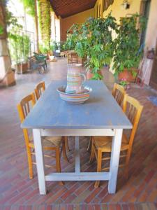 een blauwe tafel met stoelen en een theepot erop bij Dimora Altana in Brescia