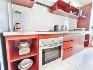 uma pequena cozinha com fogão e máquina de lavar louça em Apartamentos Marina del Sol em Coquimbo