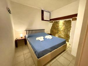 een slaapkamer met een bed met handdoeken erop bij Punta Est Trilocale Stupenda Vista Mare in Capo Coda Cavallo