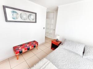 a bedroom with a bed and a picture on the wall at Departamento totalmente equipado a pasos de la Playa y Casino Enjoy in Coquimbo