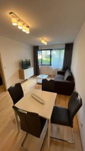 a living room with a table and chairs and a couch at Residence Garden Tower - Parking in Prague