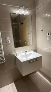 a white bathroom with a sink and a mirror at Residence Garden Tower - Parking in Prague