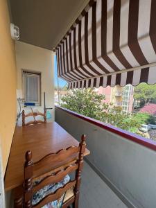 balcón con mesa de madera y ventana en Appartamento SS, en Follonica