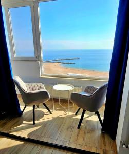 a room with a large window with a view of the beach at Sea View Studio in Constanţa