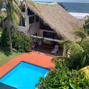 a house with a swimming pool in front of the ocean at Casa Pierre in Monterrico