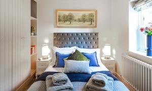 una camera da letto con un grande letto con cuscini blu di Honey Pot, Chipping Campden, parking, garden, late check-out a Chipping Campden