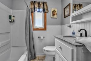 a white bathroom with a toilet and a sink at Gorgeous 2 Queen Bedroom Apartment in North Buffalo with 70 inch TV in Buffalo