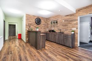una cucina con pavimenti in legno e orologio su un muro di mattoni di Room Mesi a Rozvadov