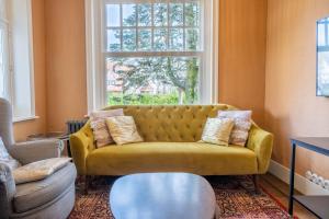 デ・ハーンにあるVilla Clair Matinの窓付きのリビングルーム(黄色のソファ付)