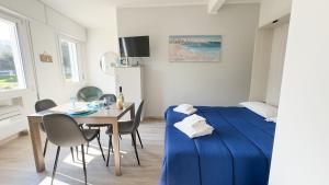 a bedroom with a blue bed and a table and chairs at Onda Blu House by Ca-Sa Check in Chioggia