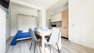 a dining room with a table and chairs and a bed at Onda Blu House by Ca-Sa Check in Chioggia