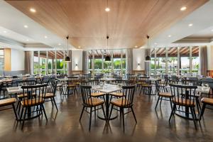 a dining room with tables and chairs and windows at Wyndham Grand Algarve in Quinta do Lago