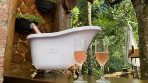 a white bath tub with two glasses of wine at Chales e Spa Exclusive - Localizado Proximo do Centro in Canela