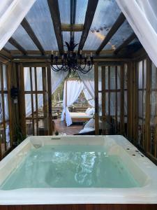 uma grande banheira num quarto com tecto em Chales e Spa Exclusive - Localizado Proximo do Centro em Canela