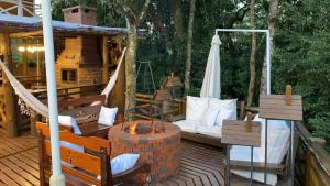a porch with a couch and a hammock on a deck at Chales e Spa Exclusive - Localizado Proximo do Centro in Canela
