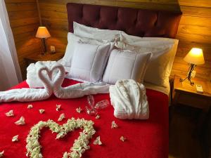 a bed with a heart made out of towels at Chales Spa Exclusive - Localizado Proximo do Centro in Canela