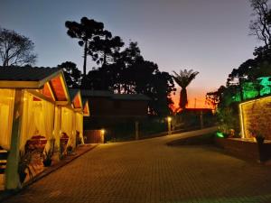an empty street at night with a sunset in the background at Chales Spa Exclusive - Localizado Proximo do Centro in Canela