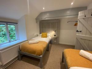 a bedroom with two beds and a window at Farmhouse & exclusive outdoor heated pool in Bryn-crug