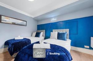 two beds in a room with blue walls at Cozy 1 Bedroom Apartment By Allure Soirée -Luxury Short Stay & Serviced Accommodation HamptonCourt with Netflix in Molesey