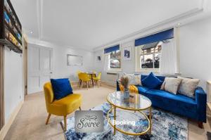 a living room with a blue couch and a table at Cozy 1 Bedroom Apartment By Allure Soirée -Luxury Short Stay & Serviced Accommodation HamptonCourt with Netflix in Molesey