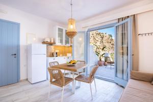 a kitchen and dining room with a table and chairs at Yploui Suites in Karpathos