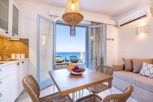 a kitchen and living room with a table with a bowl of fruit at Yploui Suites in Karpathos