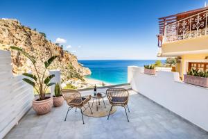 a patio with a table and chairs overlooking the ocean at Yploui Suites in Karpathos