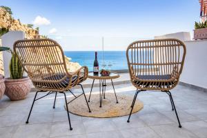 two chairs and a table with a bottle of wine at Yploui Suites in Karpathos