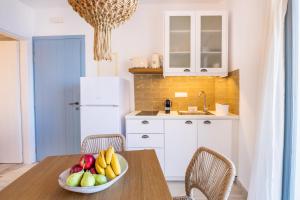a kitchen with a bowl of fruit on a table at Yploui Suites in Karpathos