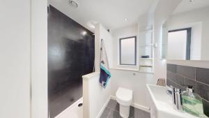 a white bathroom with a sink and a toilet at Pitts Cottage Annexe in Bladon