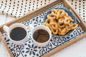 two cups of coffee and a plate of pretzels at Yploui Suites in Karpathos