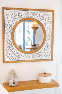 a mirror on a wall above a wooden shelf at Yploui Suites in Karpathos