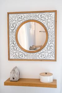 a mirror with a wooden frame on a shelf at Yploui Suites in Karpathos