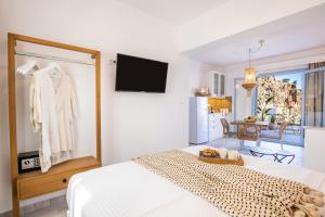 a bedroom with a bed and a tv on a wall at Yploui Suites in Karpathos