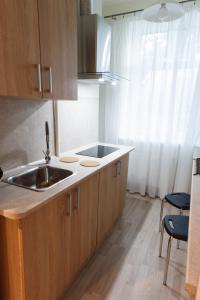 a kitchen with wooden cabinets and a sink and chairs at Quiet & Family Friendly, Free Parking, Near Park in Rīga +11 photos