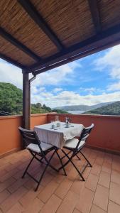 a table and two chairs on a patio with a view at La Casina di Redinoce in Marciana