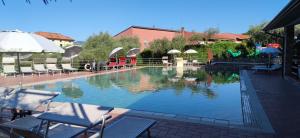 a large swimming pool with chairs and umbrellas next to it at Campeggio Gianna Golfo dei Poeti in Lerici