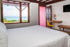 a bedroom with a bed and a view of the ocean at Sol Caribe Campo All Inclusive in San Andrés