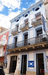 un edificio blanco con balcones en un lateral en Hotel La Perdi, en Sant Mateu