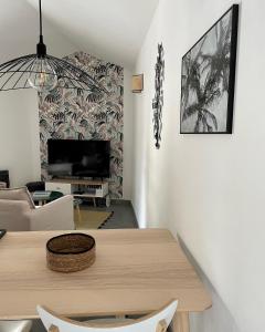 a living room with a table and a tv at Appartement ANTIGONE in Montpellier