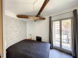 1 dormitorio con cama y ventana en Appartement ANTIGONE, en Montpellier