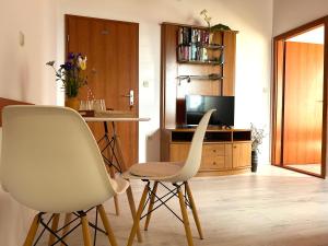 a living room with two white chairs and a television at Apartment Dino in Lopud