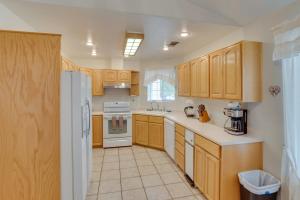 a kitchen with wooden cabinets and a white refrigerator at Page Home with Waterfall about 2 Mi to Lake Powell! in Page
