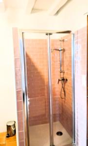 a shower in a bathroom with a brick wall at Casa Baia Hendaye in Hendaye