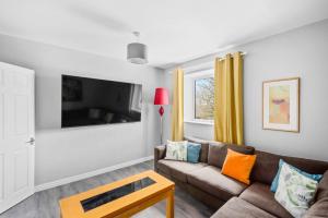 een woonkamer met een bank en een tv bij K Suites - Riding Leaze in Avonmouth