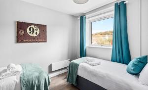 een slaapkamer met 2 bedden en een raam bij K Suites - Riding Leaze in Avonmouth