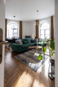 Apartmány Marienhof في زنويمو: غرفة معيشة مع أريكة خضراء وطاولة