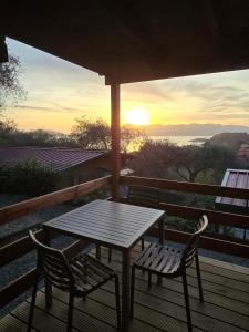 a table and chairs on a deck with the sunset at Campeggio Gianna Golfo dei Poeti in Lerici