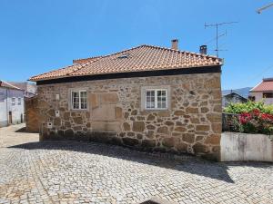 a stone building with a window on a brick street at Casa da Avó Ana - Peroviseu - Serra da Gardunha - Serra da Estrela in Pêro Viseu
