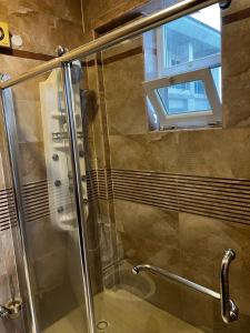 a shower with a glass door and a window at Chantel Sea View in Dar es Salaam